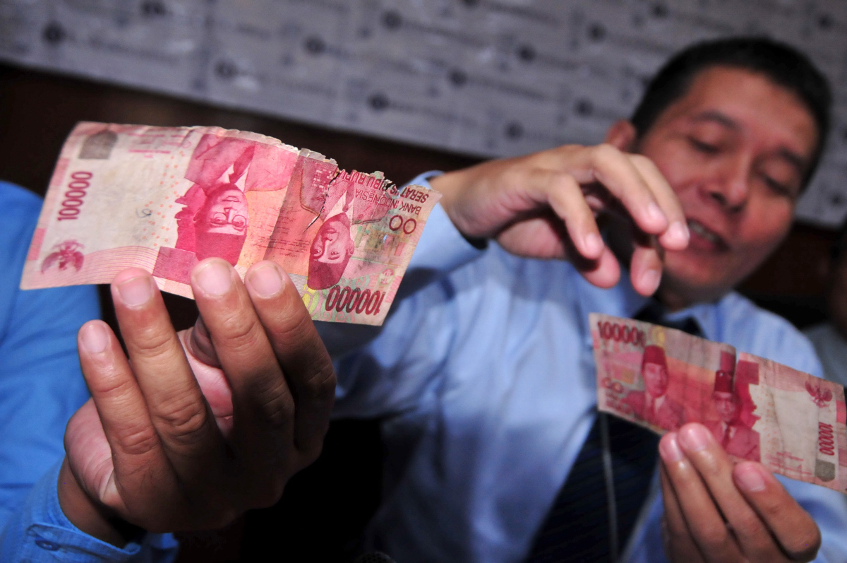 Petugas menunjukkan uang rusak sebelum dimusnahkan di Kantor Perwakilan Bank Indonesia Tegal (KPw BI), Jawa Tengah, Senin (22/2). Menurut Bank Indonesia Tegal, pemusnahan uang kertas yang rusak di KPw BI Tegal meningkat 0,44 persen dari Rp870,55 miliar pada 2014 menjadi Rp1,25 triliun pada 2015, peningkatan disebabkan oleh tingginya standar kelayakan uang beredar (standar kelusuhan uang) . ANTARA FOTO/Oky Lukmansyah/aww/16.