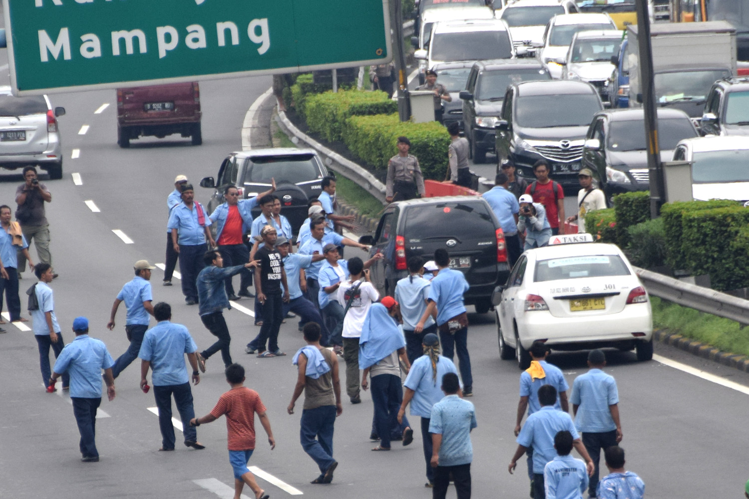 Sejumlah pengemudi angkutan umum menghentikan taksi yang beroperasi saat melakukan unjuk rasa di kawasan Senayan, Jakarta, Selasa (22/3). Dalam aksinya mereka menuntut untuk pemerintah segera menutup armada angkutan plat hitam berbasis aplikasi. TIRTO/Andrey Gromico