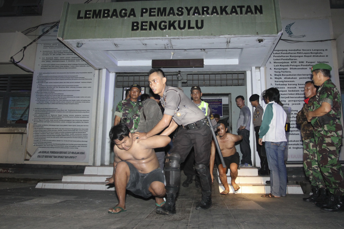 Petugas gabungan TNI dan POLRI mengevakuasi tahanan saat kebakaran yang dipicu aksi tawuran dan tembak menembak antar napi di Lembaga Permasyarakatan (Lapas) Kelas II A Malabero Kota Bengkulu, Jumat (25/3). Sebanyak 256 narapidana dievakuasi dan akan direlokasi ke Lapas Bentiring yang daya tampungnya lebih besar. ANTARA FOTO/David Muharmansyah/ama/16