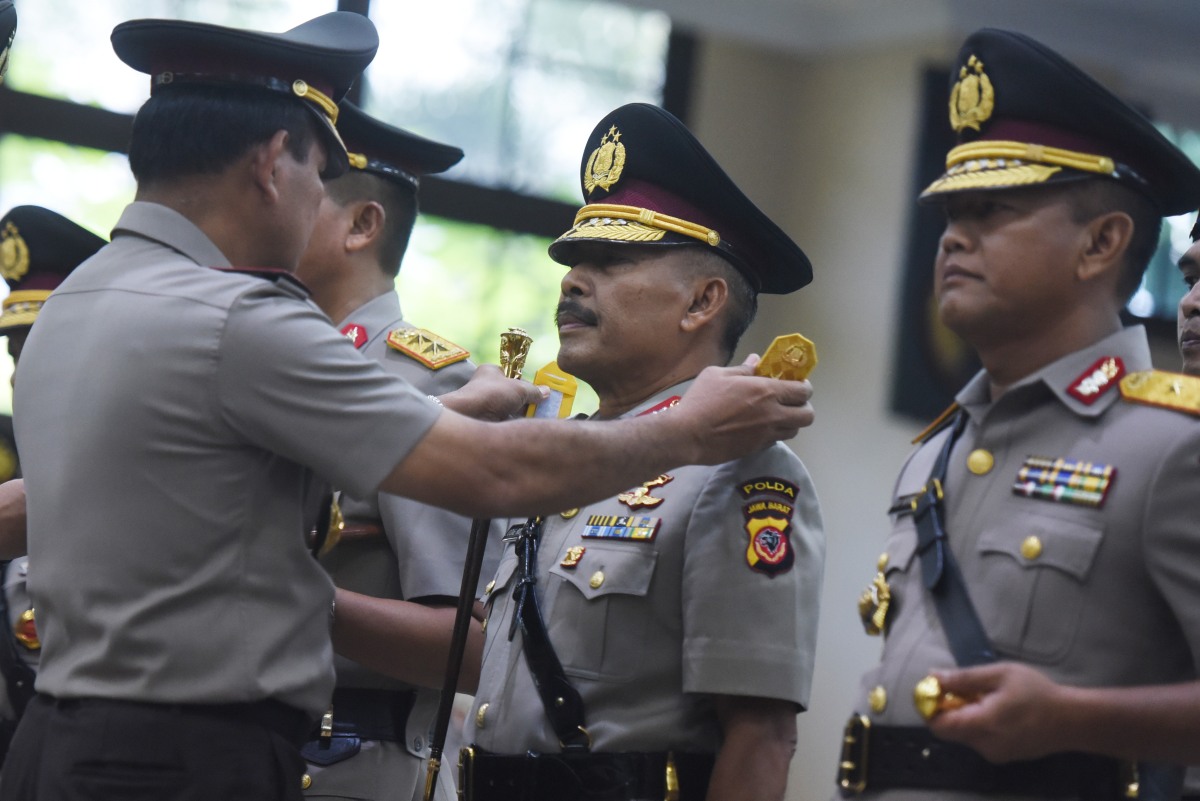 Kapolri Jenderal Pol Badrodin Haiti menyematkan tanda pangkat kepada Kapolda Jawa Barat Irjen Pol Jodie Rooseto (tengah) saat sertijab Perwira Tinggi Polri di Mabes Polri, Jakarta, Senin (21/3). Irjen Pol Jodie Rooseto resmi menjabat Kapolda Jawa Barat menggantikan Irjen Pol Moechgiyarto yang menduduki jabatan Kapolda Metro Jaya. ANTARA FOTO/Hafidz Mubarak A/kye/16