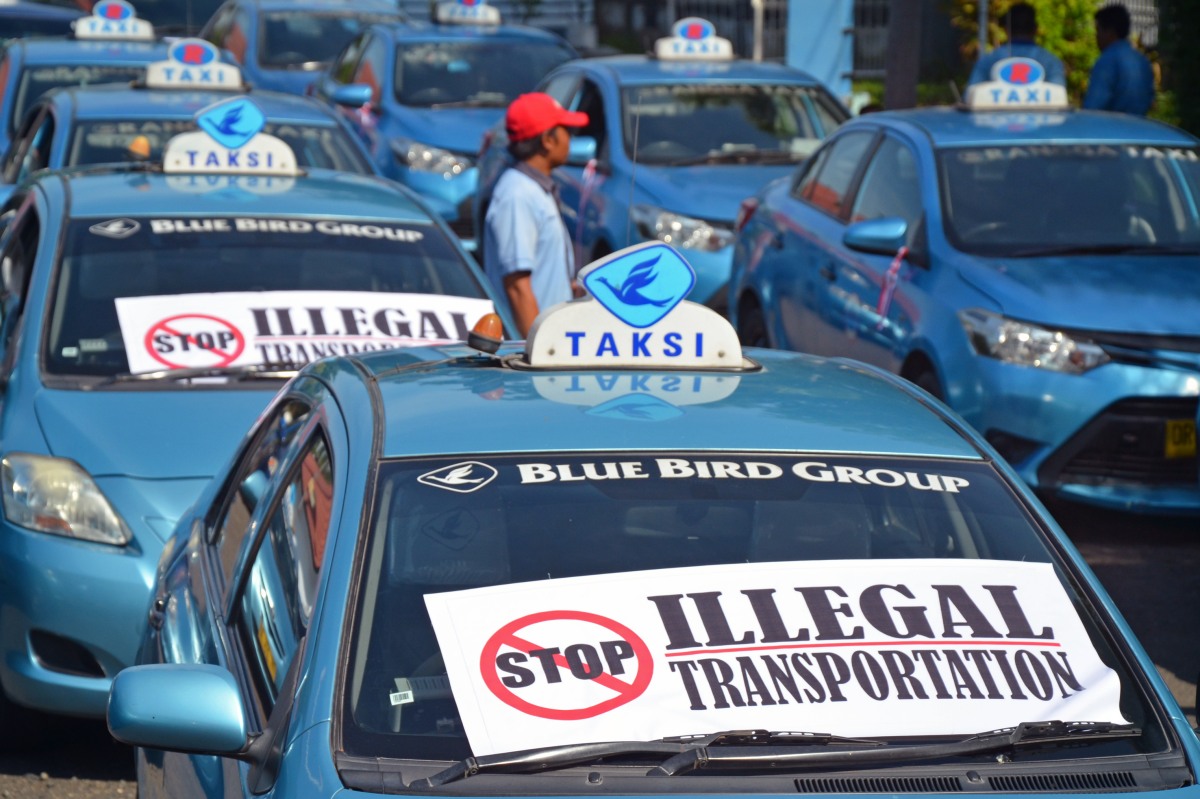 Puluhan sopir taksi memarkir kendaraan mereka saat melakukan unjukrasa di kantor Dishubkominfo Provinsi NTB di Mataram, Rabu (23/3). Puluhan sopir taksi dari perwakilan sejumlah operator taksi diantaranya Rangga Taksi, Blue Bird, Lombok Expres dan Kotasi tersebut dalam orasinya menolak kehadiran operasional taksi Grab dan taksi Uber beroperasi di wilayah NTB. ANTARA FOTO/Ahmad Subaidi/pd/16.