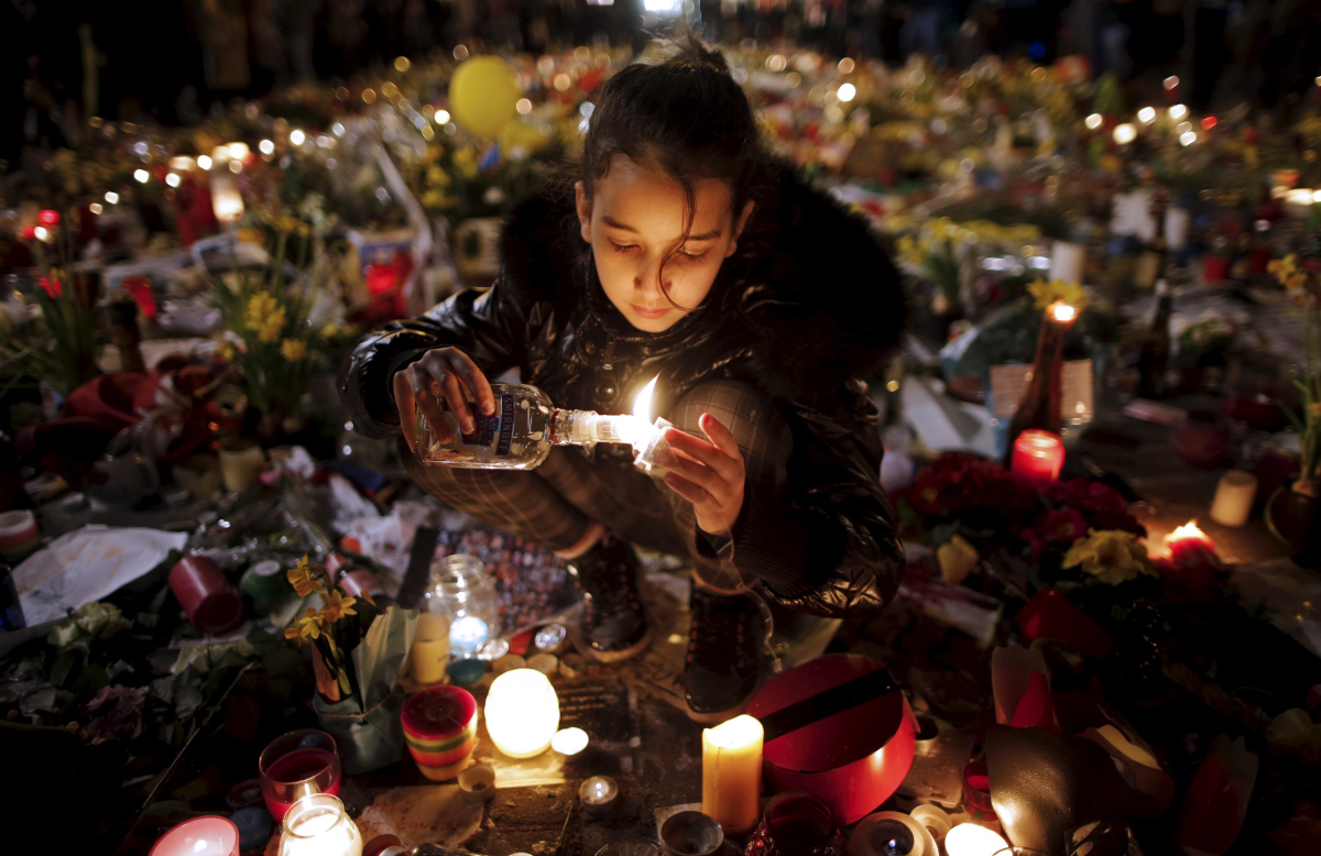 BELGIUM-BLAST/ Seorang anak perempuan menyalakan lilin ketika orang-orang memberikan penghormatan kepada korban serangan bom hari Selasa, di Place de la Bourse di Brussels, Belgia, Sabtu (26/3). ANTARA FOTO/REUTERS/Christian Hartmann/cfo/16