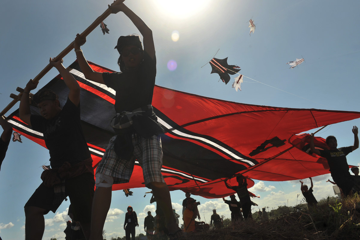 Sekelompok pemuda menggotong layang-layang tradisional jenis ikan pada Festival ke-37 Layang-Layang Bali di Pantai Padanggalak, Denpasar, Jumat (3/7). Festival untuk atraksi pariwisata tersebut berlangsung 3-5 Juli 2015 dengan melibatkan 1.070 layan-layang tradisional dan kreasi baru. ANTARA FOTO/Nyoman Budhiana/Rei/pd/15.