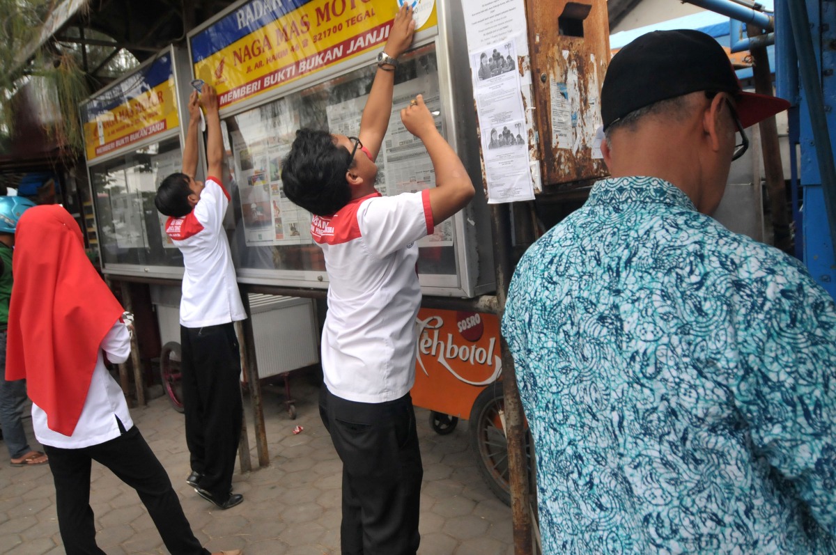 Petugas memasang stiker stop narkoba di Tegal, Jawa Tengah, Kamis (24/3). Penempelan stiker stop narkoba oleh Badan Narkotika Nasional (BNN) di sejumlah tempat keramaian seperti mini market, stasiun, ATM bank dan kantor pemerintahan tersebut sebagai kampanye memerangi bahaya penyalahgunaan narkoba dan gerakan bersama untuk mempersempit peredaran narkoba. ANTARA FOTO/Oky Lukmansyah/ama/16