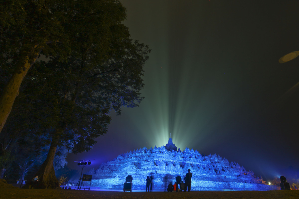 Pengunjung mengamati Candi Borobudur yang disinari cahaya biru saat acara HUT Persatuan Bangsa Bangsa (PBB) ke-70 bertajuk 