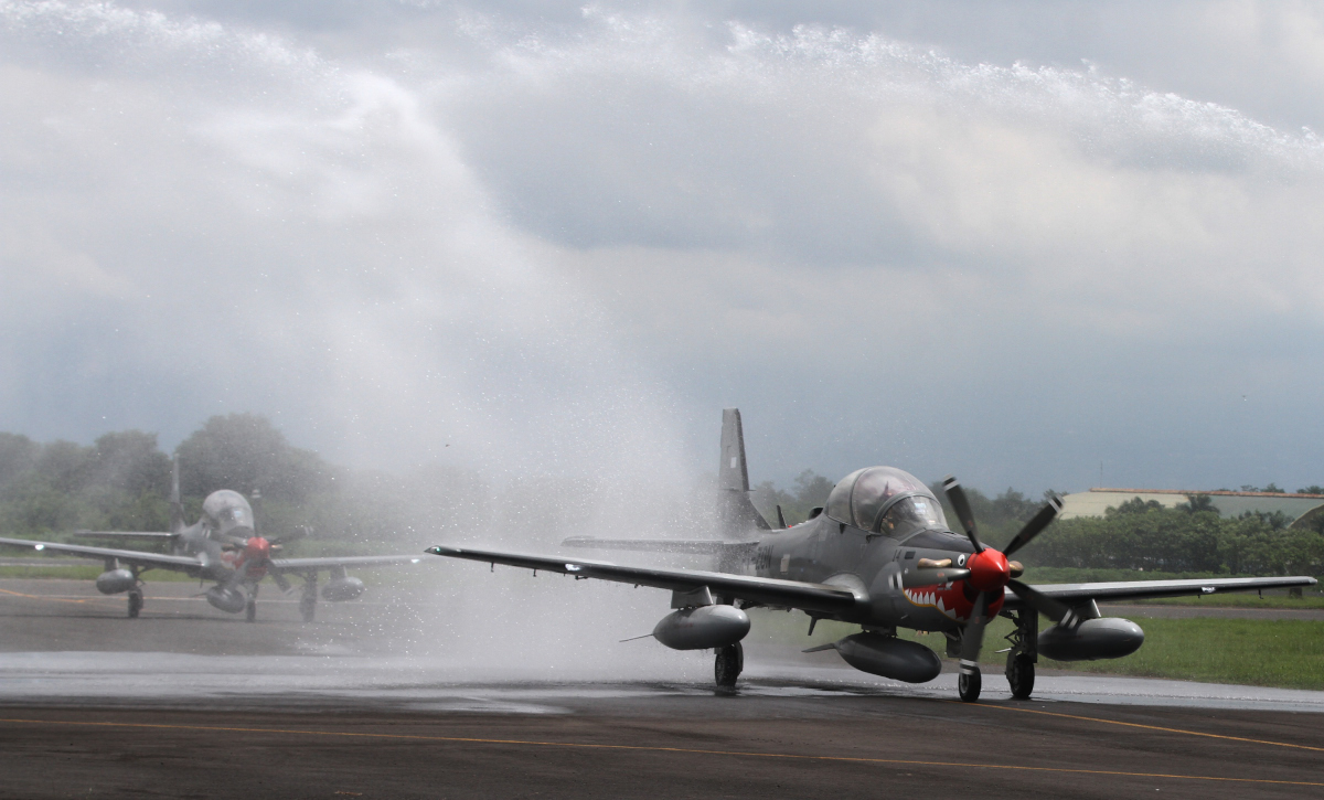 Salah satu dari empat pesawat Super Tucano disambut dengan guyuran air dari mobil pemadam kebakaran saat mendarat di Skadron 21 Lanud Abdul Rahman Saleh, Malang, Jawa Timur, Senin (29/2). Kedatangan terakhir empat pesawat tempur taktis dari Brazil tersebut melengkapi dua belas pesawat lain yang telah tiba secara berkala sejak tahun 2012. ANTARA FOTO/Ari Bowo Sucipto/nz/16.