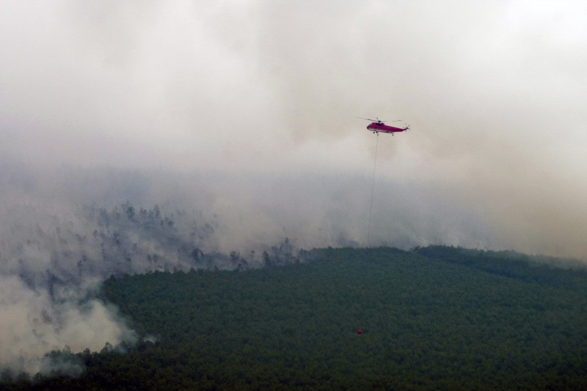 Helikopter jenis Sikorsky dari Badan Nasional Penanggulangan Bencana Nasional melakukan pengeboman air untuk memadamkan kebakaran di konsesi perusahaan hutan tanaman industri yang berbabatasan dengan Cagar Biosfer Giam Siak Kecil-Bukit Batu di Kabupaten Bengkalis, Riau, Selasa (1/4). Satgas Tanggap Darurat Asap Riau terus berupaya melakukan pemadaman kebakaran dan asap sesuai target dari Presiden Susilo Bambang Yudhoyono yang harus tuntas pada 4 April. ANTARA FOTO/FB Anggoro/ed/pd/14.
