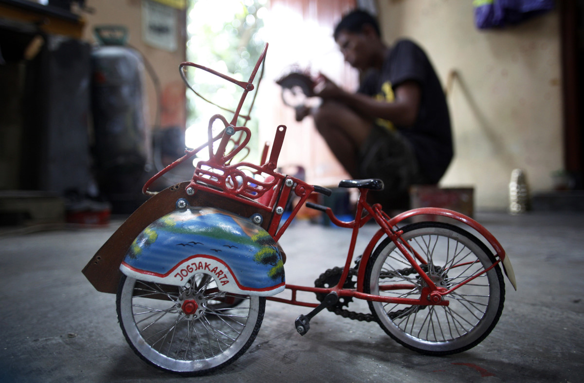 Pekerja menyelesaikan kerajinan miniatur becak yang terbuat dari tembaga dan kuningan di Walidi Craft, Pakualaman, Yogyakarta, Selasa (24/3). Kerajinan yang sudah empat generasi sejak 1944 tersebut mampu membuat aneka ragam kerajinan beserta miniatur berbahan tembaga dan kuningan yang dipasarkan di berbagai daerah di Tanah Air dan diekspor di Malaysia, Singapura, Belanda, Italia dari harga Rp10.000 hingga Rp400.000 perbuah. ANTARA FOTO/Sigid Kurniawan/Rei/pd/15.