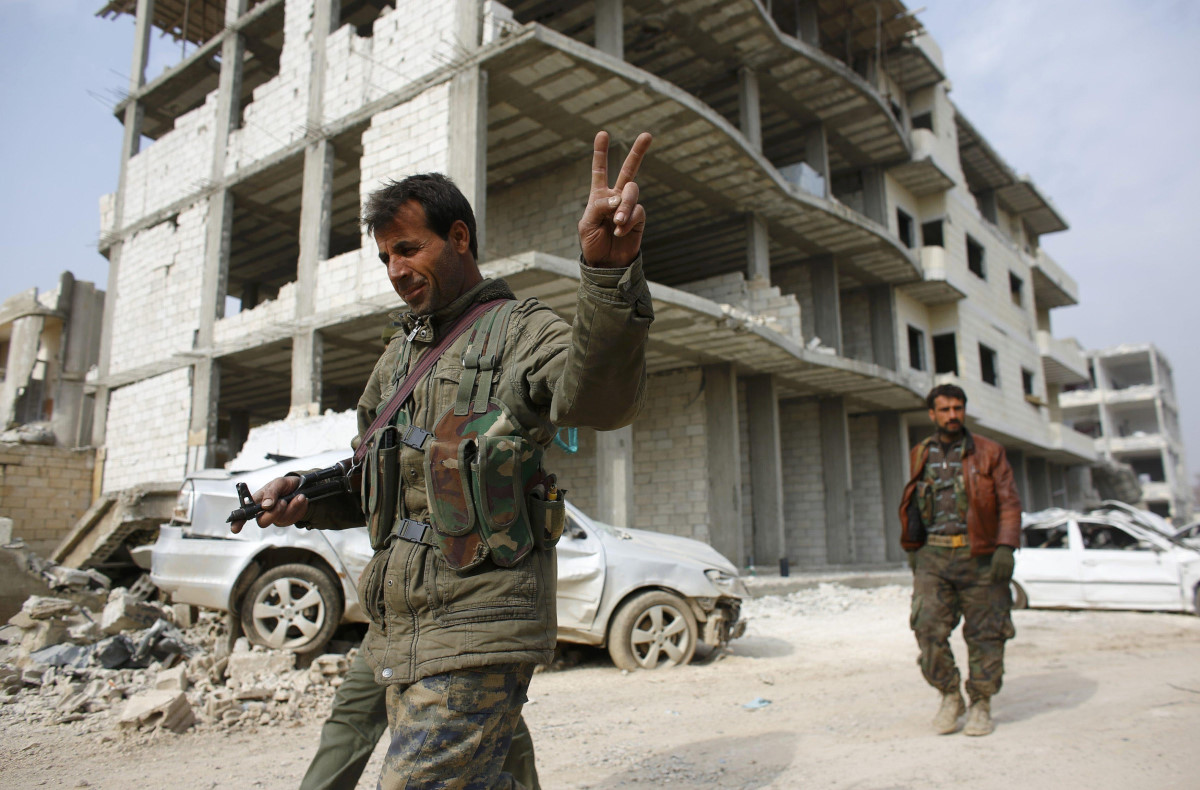 A fighter of the Kurdish People's Protection Units (YPG) flashes a V-sign as he patrols in the streets in the northern Syrian town of Kobani January 28, 2015. Kurdish forces battled Islamic State fighters outside Kobani on Tuesday, a monitoring group said, a day after Kurds said they had taken full control of the northern Syrian town following a four-month battle. Known as Ayn al-Arab in Arabic, the mainly Kurdish town close to the Turkish border has become a focal point in the international fight against Islamic State, an al Qaeda offshoot that has spread across Syria and Iraq. REUTERS/Osman Orsal (SYRIA - Tags: POLITICS CONFLICT TPX IMAGES OF THE DAY) *** Local Caption *** Seorang pejuang dari Unit Perlindungan Rakyat Kurdi (YPG) mengacungkan kedua jarinya saat ia berpatroli di Kobani, Syriah, Rabu (28/1). Pasukan Kurdi yang bertempur melawan militan Negara Islam di luar kota Kobani Selasa lalu, kata kelompok pemantau, sehari setelah pasukan Kurdi mengatakan mereka telah mengambil alih kendali kota di utara Suriah itu setelah bertempur selama empat bulan. Dikenal dengan nama Ayn al-Arab dalam bahasa Arab, kota Suriah di dekat perbatasan Turki itu telah menjadi titik perhatian dalam pertempuran internasional melawan Negara Islam. ANTARA FOTO/REUTERS/Osman Orsal/ox/15.