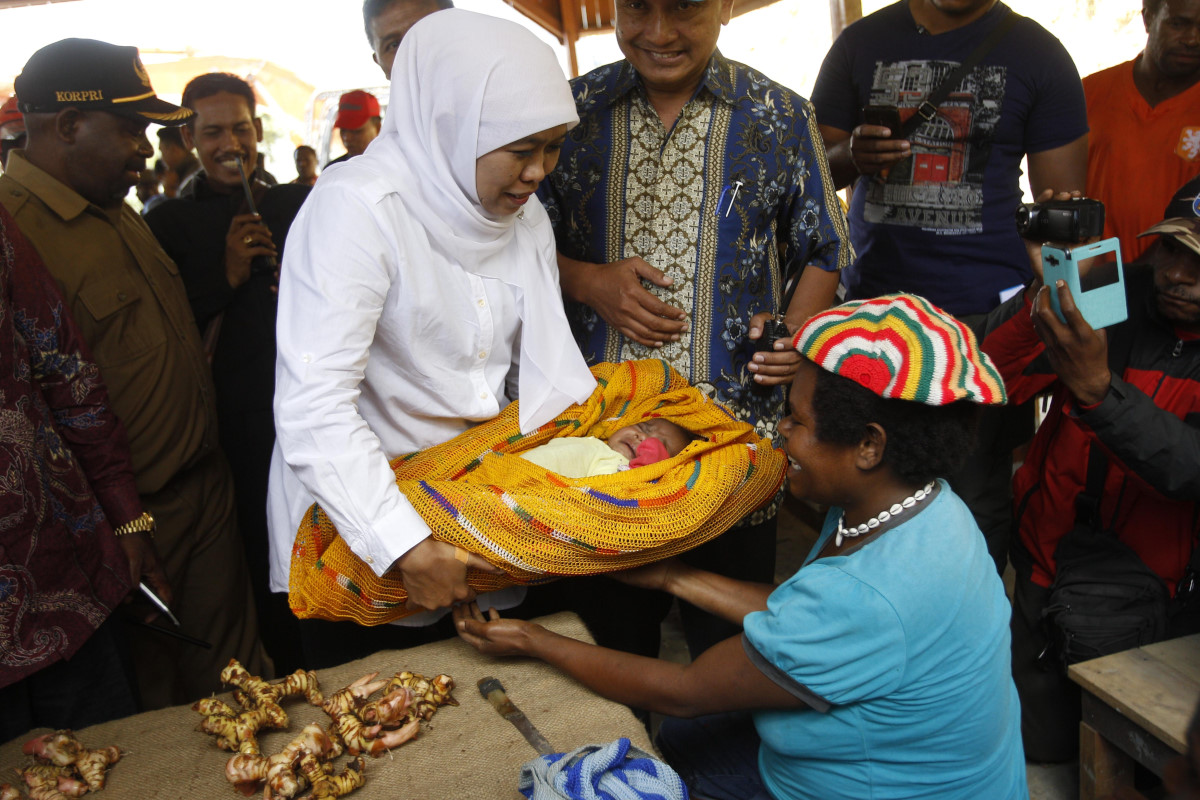 Mensos Khofifah Indar Parawansa (kiri) menyapa pedagang pasar tradisional Kabupaten Tolikara, Papua, Rabu (23/9). Dalam kesempatan itu mensos juga melakukan sosialisasi pengunaan kartu bagi masyarakat yang kurang mampu. ANTARA FOTO/HO/Trisnadi/nz/15.