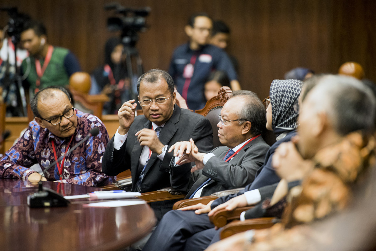 Direktur Litigasi dan Bantuan Hukum Otoritas Jasa Keuangan (OJK) Tongam L Tobing (kiri) berbincang dengan Deputi Komisioner Pengawasan Pasar Modal OJK Sarjito (kedua kiri) dan Anggota Dewan Komisioner OJK Keuangan merangkap Kepala Eksekutif Pengawasan Perbankan OJK Nelson Tampubolon (ketiga kiri) sebelum menjalani sidang putusan perkara pengujian UU OJK di gedung MK, Jakarta, Selasa (4/8). Mahkamah Konstitusi menolak gugatan Tim Pembela Kedaulatan Ekonomi Bangsa (TPKEB) atas Undang-Undang Otoritas Jasa Keuangan (OJK) Nomor 21 Tahun 2011 tentang pembubaran OJK, karena dalil yang digunakan pemohon tidak memiliki alasan yang kuat. ANTARA FOTO/M Agung Rajasa/ama/15.