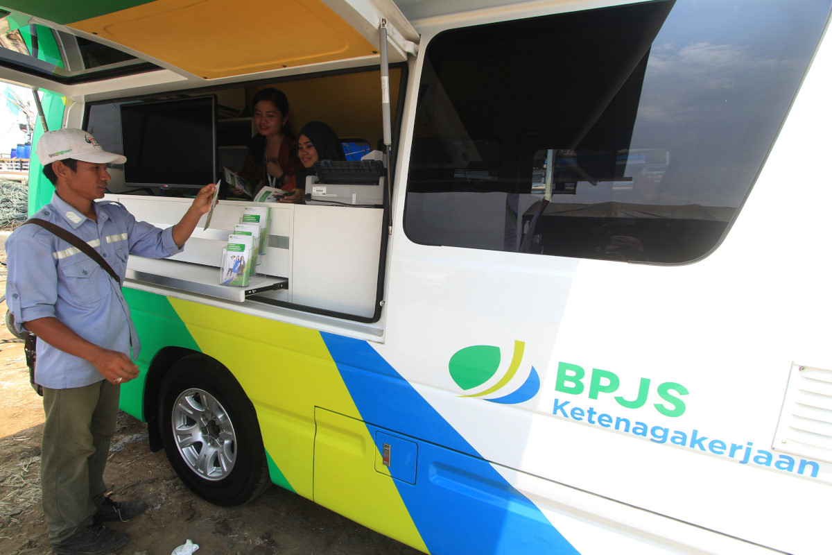 Petugas memberikan penjelasan kepada seorang warga di Mobil Keliling BPJS Ketenagakerjaan di Karangsong, Indramayu, Jawa Barat, Selasa (17/11). BPJS Ketenagakerjaan menggunakan layanan mobil keliling untuk memudahkan warga mendapatkan akses pelayanan BPJS. ANTARA FOTO/Dedhez Anggara/aww/15.