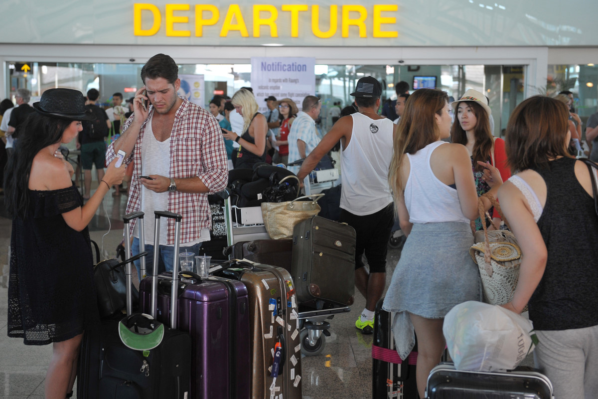 Sejumlah warga negara asing menunggu kejelasan penerbangannya di Terminal Internasional Bandara Ngurah Rai, Denpasar, Kamis (6/8). Bandara Ngurah Rai kembali menutup aktivitas semua penerbangan pada Kamis (6/8) mulai pukul 12.00 WITA karena peningkatan gangguan debu vulkanik Gunung Raung. ANTARA FOTO/Nyoman Budhiana/aww/15.