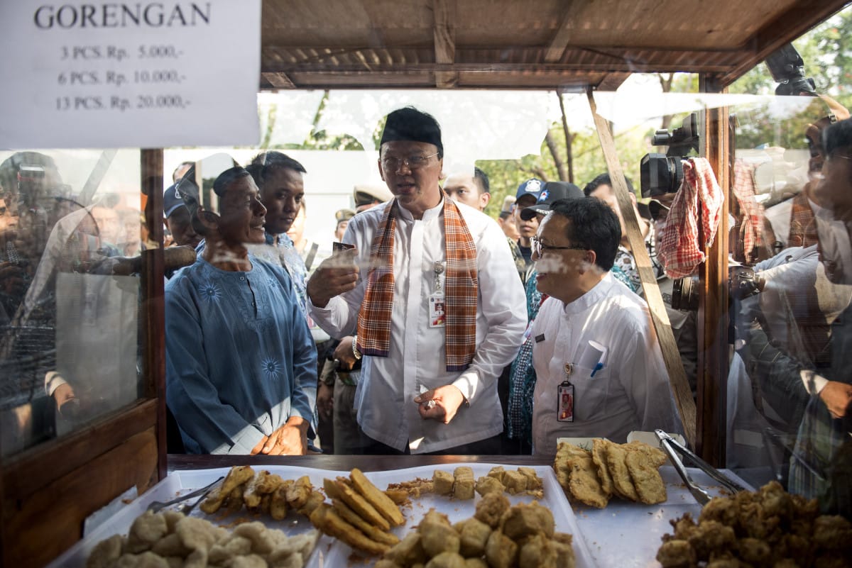 Gubernur DKI Jakarta Basuki Basuki Tjahaja Purnama (tengah) berbincang dengan pedagang kaki lima seusai peresmian kawasan Lenggang Jakarta, Lapangan Irti Monas, Jakarta, Jumat (22/5). Lenggang Jakarta merupakan program penertiban pedagang kaki lima (PKL) dan dengan program ini kelas PKL di DKI akan mendapatkan penghasilan Rp 10 sampai Rp 12 juta per bulan. ANTARA FOTO/M Agung Rajasa/ed/mes/15.