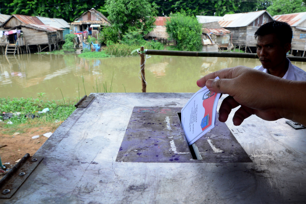 Seorang warga memasukkan surat suara ke dalam kotak suara saat menggunakan hak pilih pada Pilkada Kabupaten Ogan Ilir di TPS 2 di Desa Ibul Besar 2 Kecamatan Pemulutan, Sumatera Selatan, Rabu (9/12). Pilkada Kabupaten Ogan Ilir diikuti tiga pasangan calon. ANTARA FOTO/Yahanan Sulam/aww/15.