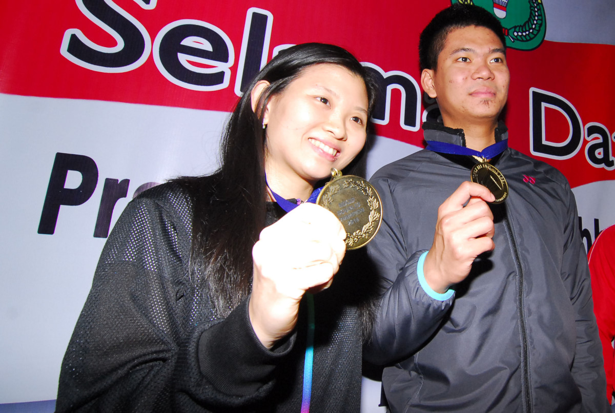 Pasangan ganda campuran Praveen Jordan (kanan), Debby Susanto (kiri) memegang medali sesaat tiba di terminal 2 D bandara Soekarno Hatta, Tangerang, Banten, Selasa (15/3) malam. Pasangan ini menjuarai ganda campuran di kejuaraan All England Open Super Series Premier 2016 setelah menaklukan pasangan Denmark. ANTARA FOTO/Lucky R./pd/15