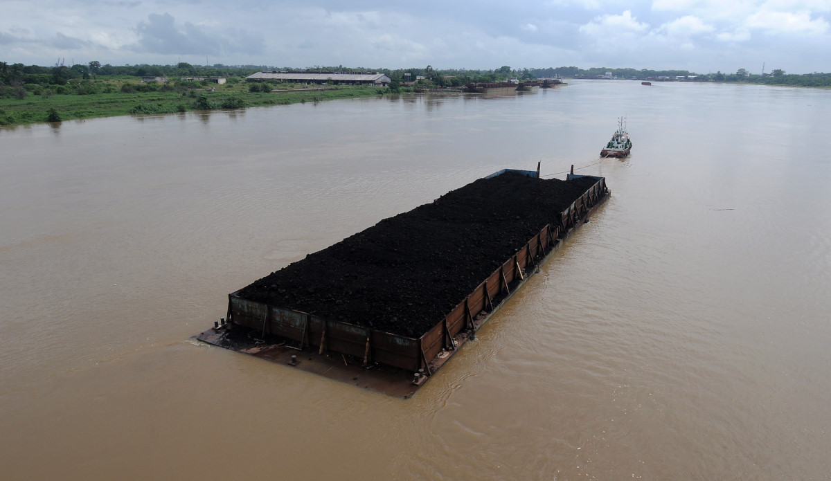 Kapal Tongkang pembawa batubara melintasi aliran Sungai Batanghari di Kabupaten Muarojambi, Jambi, Rabu (27/1). Dinas Energi Sumber Daya Mineral (ESDM) Provinsi Jambi menyebutkan, produksi batubara daerah itu sepanjang 2015 hanya mencapai 3,6 juta ton atau anjlok sebesar 60 persen dari produksi tahun sebelumnya yang mencapai 8,2 juta ton karena terdampak berhenti beroperasinya sejumlah perusahaan pertambangan setempat selama turunnya harga jual. ANTARA FOTO/Wahdi Septiawan/foc/16.