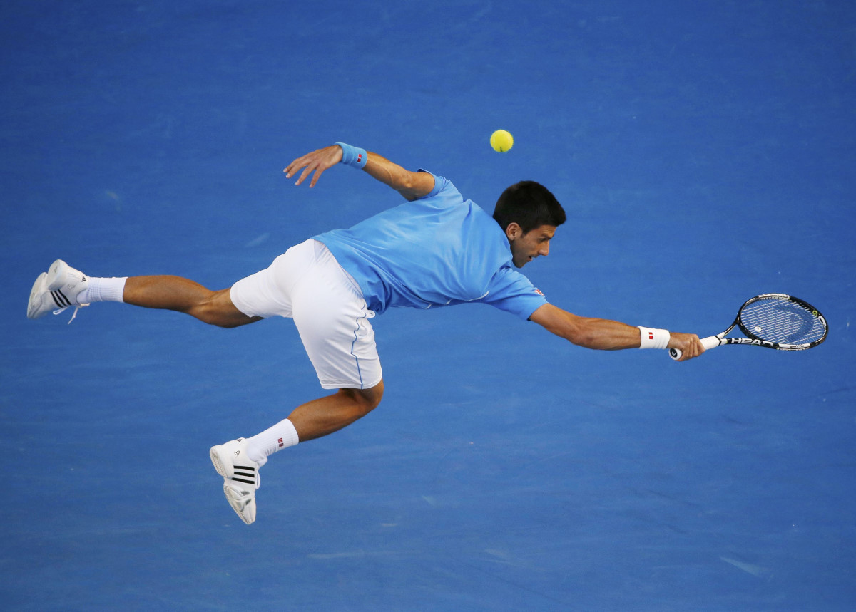 Novak Djokovic of Serbia lunges to hit a return against Milos Raonic of Canada during their men's singles quarter-final match at the Australian Open 2015 tennis tournament in Melbourne January 28, 2015. REUTERS/Carlos Barria (AUSTRALIA - Tags: SPORT TENNIS TPX IMAGES OF THE DAY) *** Local Caption *** Petenis Serbia Novak Djokovic berusaha mengembalikan bola ke arah petenis Kanada Milos Raonic di perempat final turnamen tenis Australia Terbuka di Melbourne, Rabu (28/1). Djokovic melaju ke semifinal setelah mengalahkan Raonic 7-6. 6-4. 6-2. ANTARA FOTO/REUTERS/Carlos Barria/ox/15.