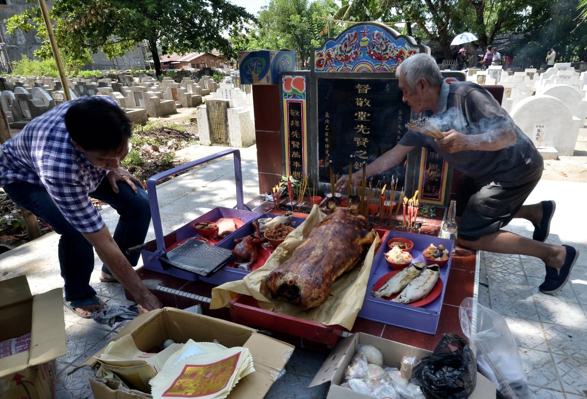 Warga Tionghoa mempersiapkan berbagai sesajian di depan makam pada perayaan tradisi Ceng Beng di Pekuburan China Pannara, Antang, Makassar, Sulawesi Selatan, Jumat (25/3). Ceng Beng atau Qing Ming merupakan ritual suci bagi masyarakat Tionghoa yang dilakukan secara turun-temurun setahun sekali dengan berziarah ke makam orang tua dan leluhur sebagai bentuk penghormatan kepada mereka yang telah tiada. ANTARA FOTO/Dewi Fajriani/aww/16.