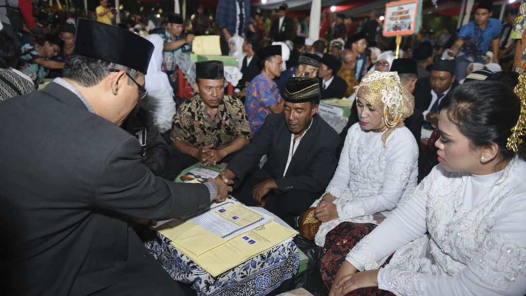 Pengantin melakukan ijab kabul saat mengikuti nikah massal di Thamrin Park ride, Jakarta, Minggu (31/12). ANTARA FOTO/Hafidz Mubarak A. NIKAH MASSAL MALAM PERGANTIAN TAHUN
