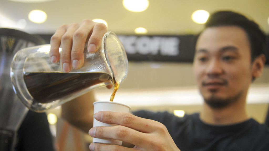 Seorang barista mengamati biji kopi yang akan diolah pada Indonesia Coffee Events (ICE) 2018 di Surabaya, Jawa Timur, Minggu (21/1). ANTARA FOTO/Zabur Karuru. INDONESIA COFFEE EVENTS 2018