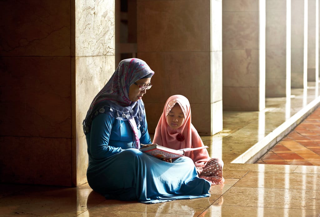 Ilustrasi mengajarkan anak mengaji. Getty Images/iStockphoto Ilustrasi Mengajarkan Mengaji