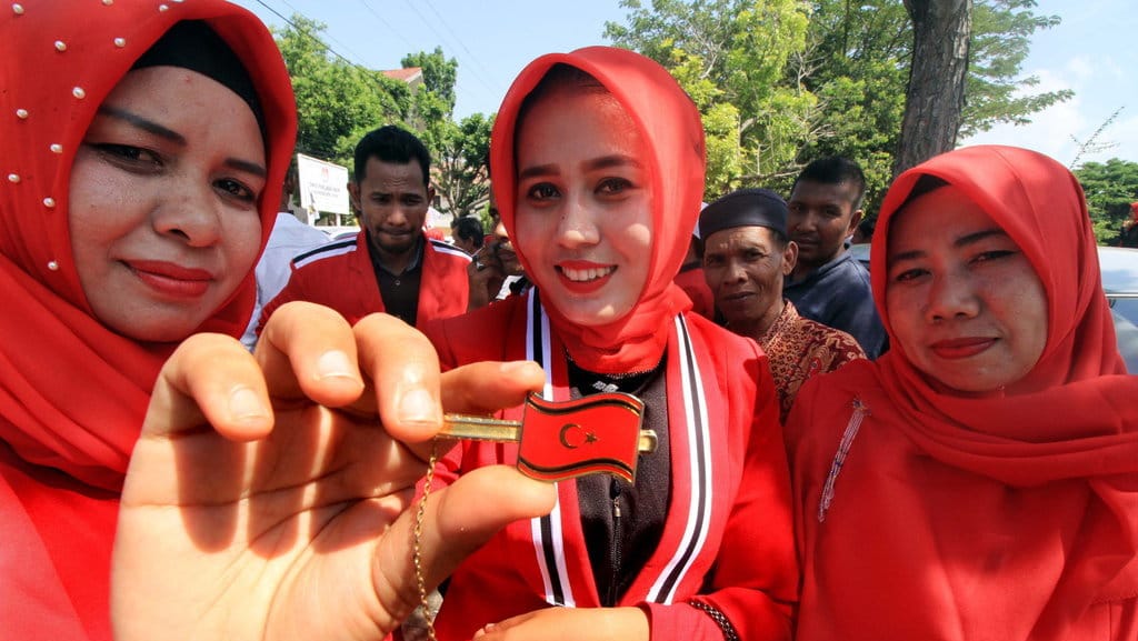 Bakal Calon Legislatif (bacaleg) perempuan dari Partai Aceh (PA) menunjukkan pin partai usai mendaftar di kantor Komisi Independen Pemilihan (KIP) Aceh Utara di Kota Lhokseumawe, Aceh, Senin (16/7/2018). ANTARA FOTO/Rahmad BACALEG PEREMPUAN PARTAI ACEH