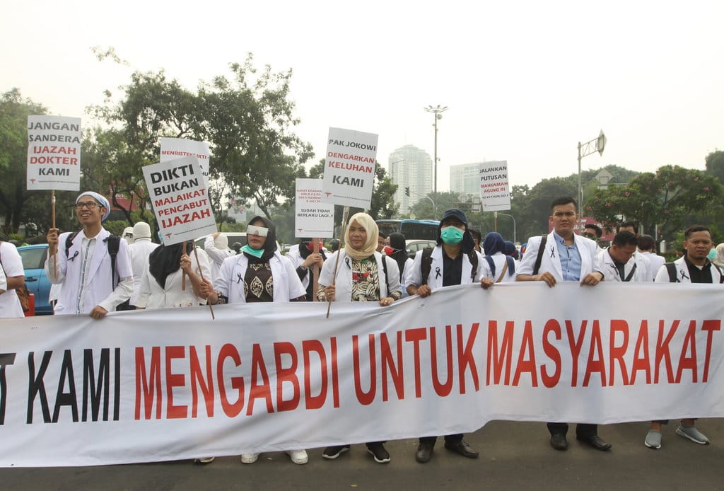 Pendemo yang tergabung dalam Pergerakan Dokter Muda Indoonesia berunjuk rasa di depan Istana Negara, Jakarta, Kamis (19/7/2018). ANTARA FOTO/Reno Esnir UNJUK RASA DOKTER MUDA INDONESIA
