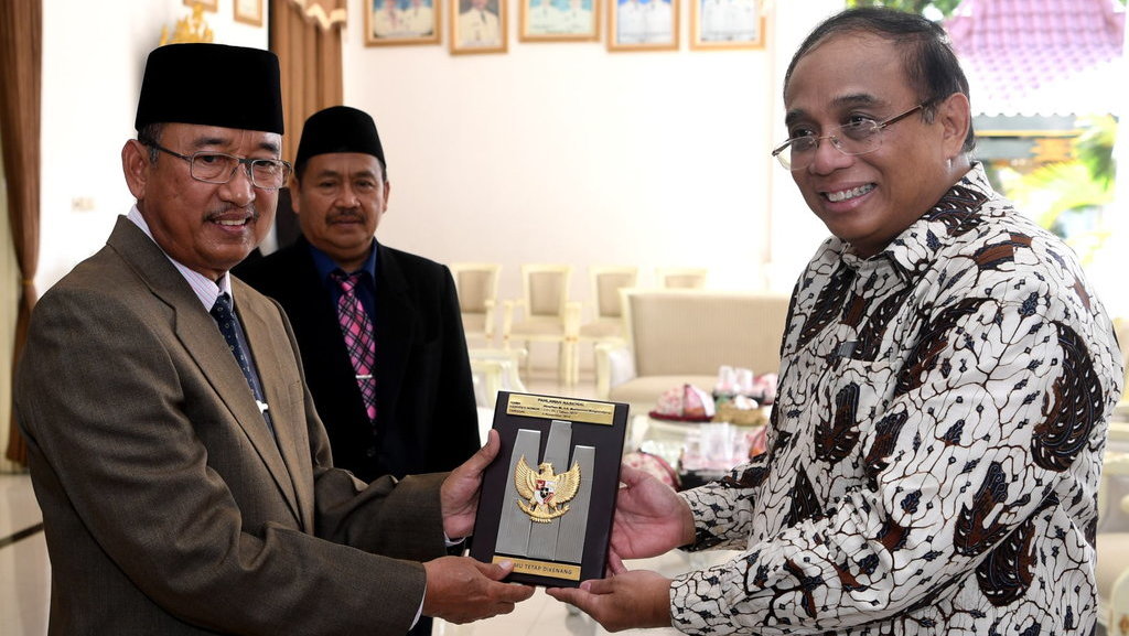 Cucu Pahlawan Nasional Mayjen TKR HR Mohamad Mangoenprodjo, Indroyono Soesilo (kanan), menyerahkan plakat Pahlawan Nasional Mayjen TKR HR Mohamad Mangoenprodjo kepada Wakil Bupati Ponorogo Soedjarno (kiri) seusai upacara peringatan Hari Pahlawan di Ponorogo, Jawa TImur, Sabtu (10/11/2018). ANTARA FOTO/Zabur Karuru PENYERAHAN PLAKAT PAHLAWAN HR MOHAMAD PONOROGO