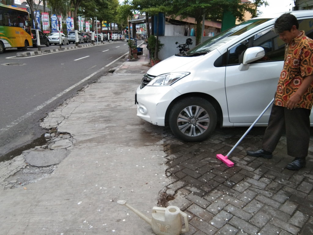 Cleaning service salah satu kantor di Jalan Mayor Suryotomo membersihkan tahi burung yang ada di sekitar halaman kantor pada Jumat (23/11/2018). tirto.id/Dipna Videlia Cleaning service