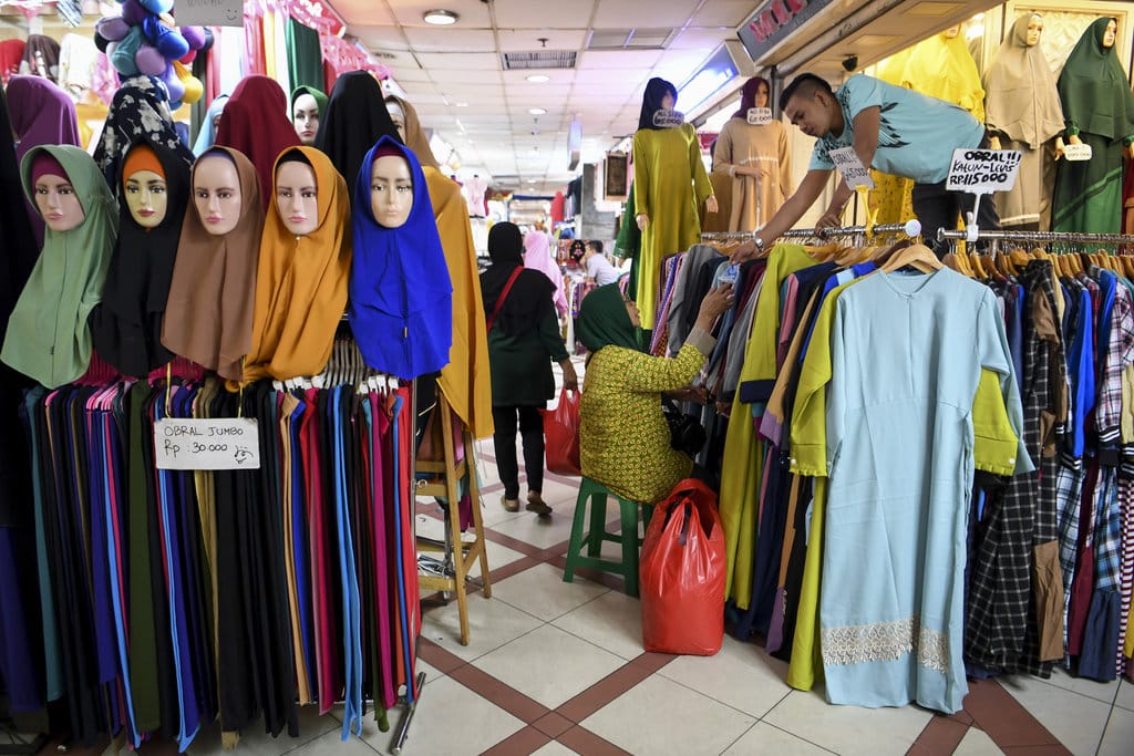 Warga dan penjual pakaian melakukan transaksi jual beli di Pasar Tanah Abang, Jakarta, Senin (17/6/2019). NTARA FOTO/Hafidz Mubarak A/nz. AKTIVITAS DI PASAR TANAH ABANG