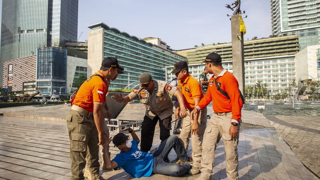 Petugas mengamankan aktivis Greenpeace saat menggelar aksi di Monumen Selamat Datang, Bundaran HI, Jakarta, Rabu (23/10/2019). ANTARA FOTO/Dhemas Reviyanto/ama. AKSI GREENPEACE DI MONUMEN SELAMAT DATANG