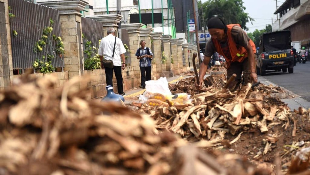 Petugas memotong batang pohon yang telah ditebang di trotoar sisi Jalan Pengangsaan Timur, Cikini, Jakarta Pusat, Senin (4/11/2019). tirto.id/Andrey Gromico Pohon Ditebang di Trotoar Cikini