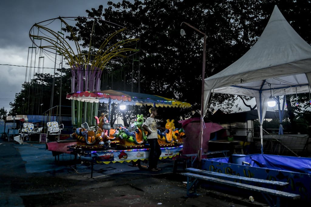 Penjaga wahana berdiri di lokasi Pasar Malam yang tutup di Kanal Banjir Timur, Jakarta Timur, Minggu (10/5/2020). ANTARA FOTO/Muhammad Adimaja/aww. WAHANA PASAR MALAM BERHENTI BEROPERASI