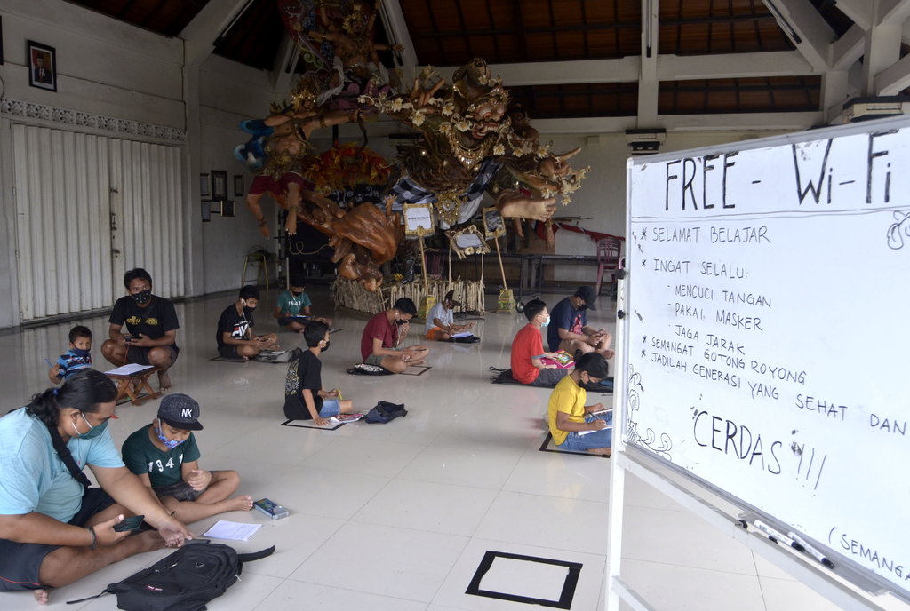 Sejumlah siswa belajar secara daring dengan mengakses jaringan internet gratis yang disediakan di Balai Banjar Petangan Gede, Desa Ubung Kaja, Denpasar, Bali, Senin (20/7/2020). ANTARA FOTO/Fikri Yusuf/wsj. INTERNET GRATIS UNTUK PEMBELAJARAN DARING