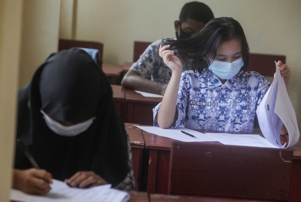 Siswa Kelas IX mengikuti Ujian Akhir Sekolah (UAS) secara luar jaringan (luring) di SMP Negeri 1 Palangkaraya, Kalimantan Tengah, Kamis (8/4/2021). ANTARA FOTO/Makna Zaezar/rwa. UJIAN AKHIR SEKOLAH SMP SECARA TATAP MUKA