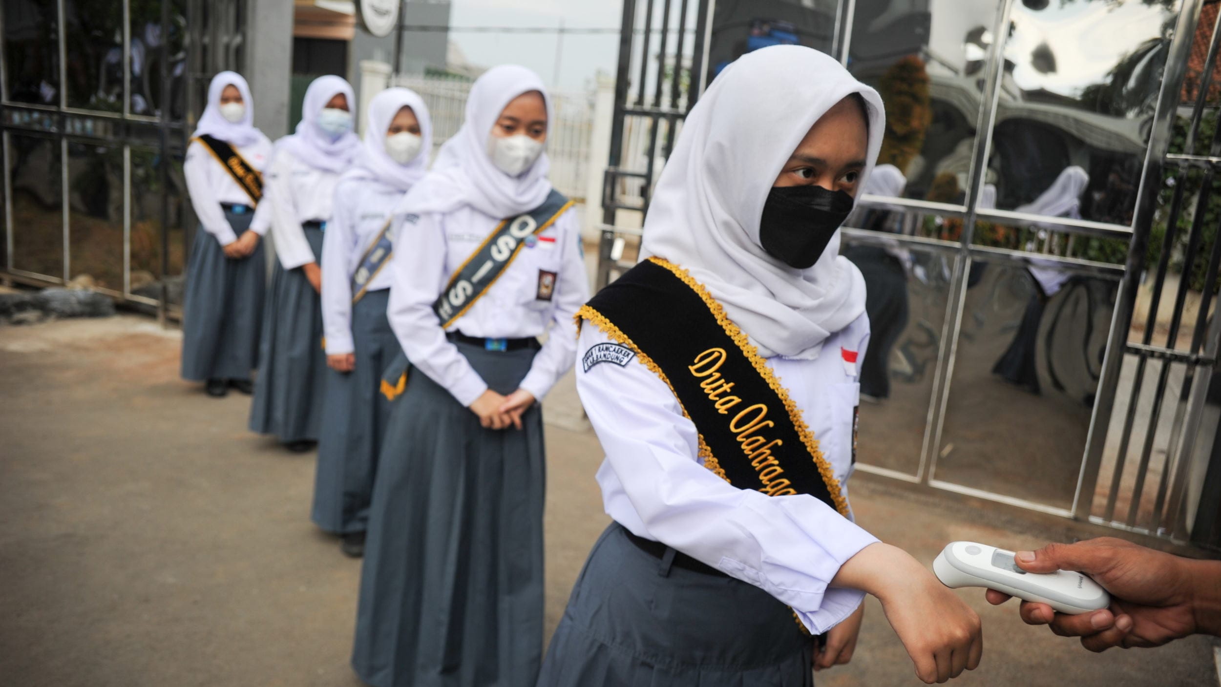 Petugas memeriksa suhu tubuh siswa sebelum mengikuti pembelajaran tatap muka terbatas di SMAN 1 Rancaekek, Kabupaten Bandung, Jawa Barat, Senin (6/9/2021).ANTARA FOTO/Raisan Al Farisi/hp. PEMBELAJARAN TATAP MUKA TERBATAS DI KABUPATEN BANDUNG
