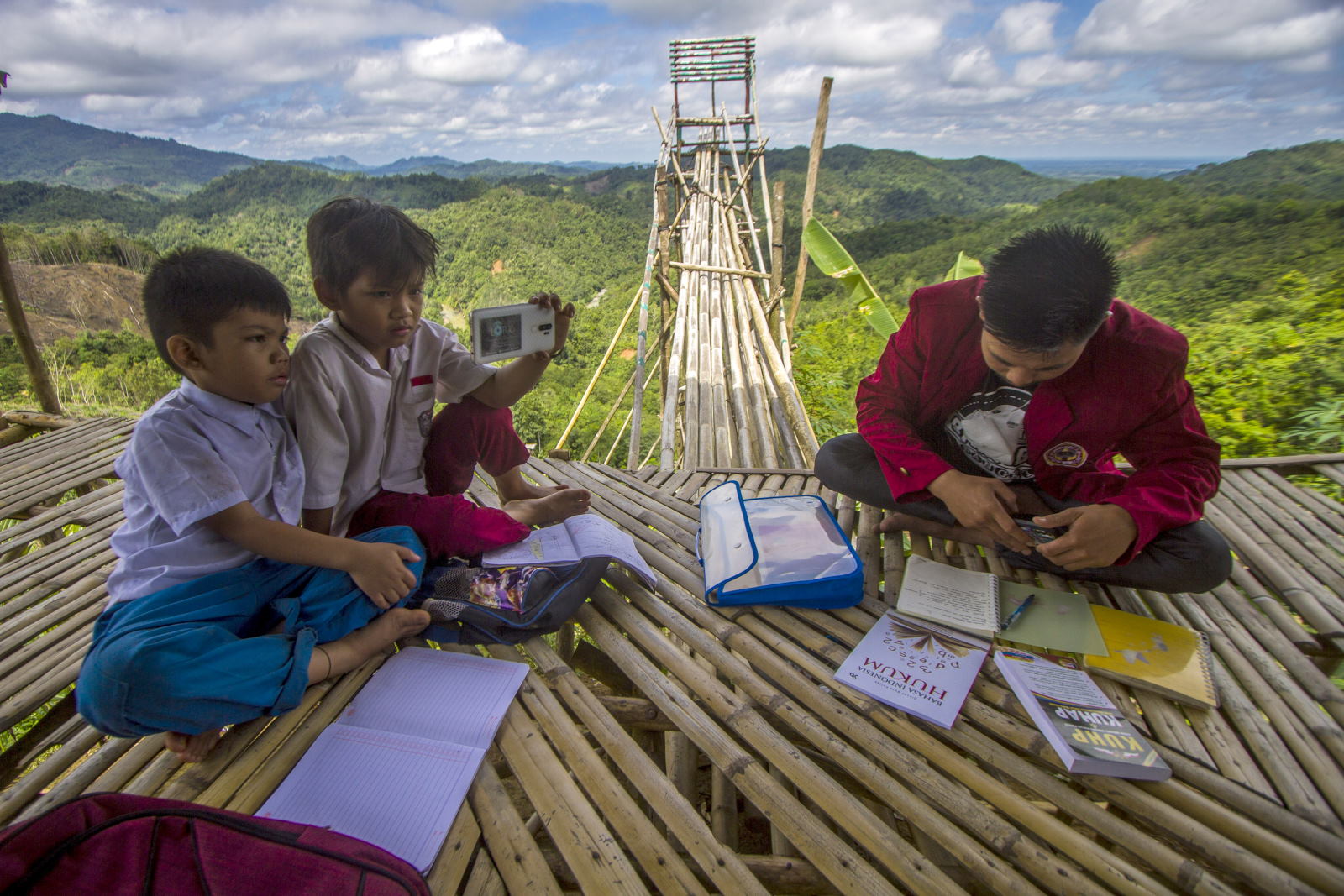 Siswa dan mahasiswa belajar secara daring di pondok puncak bukit Merona, Desa Hinas Kanan, Kabupaten Hulu Sungai Tengah, Kalimantan Selatan, Senin (27/9/2021). ANTARA FOTO/Bayu Pratama S/pras. SUSAH SINYAL BELAJAR DI PUNCAK BUKIT