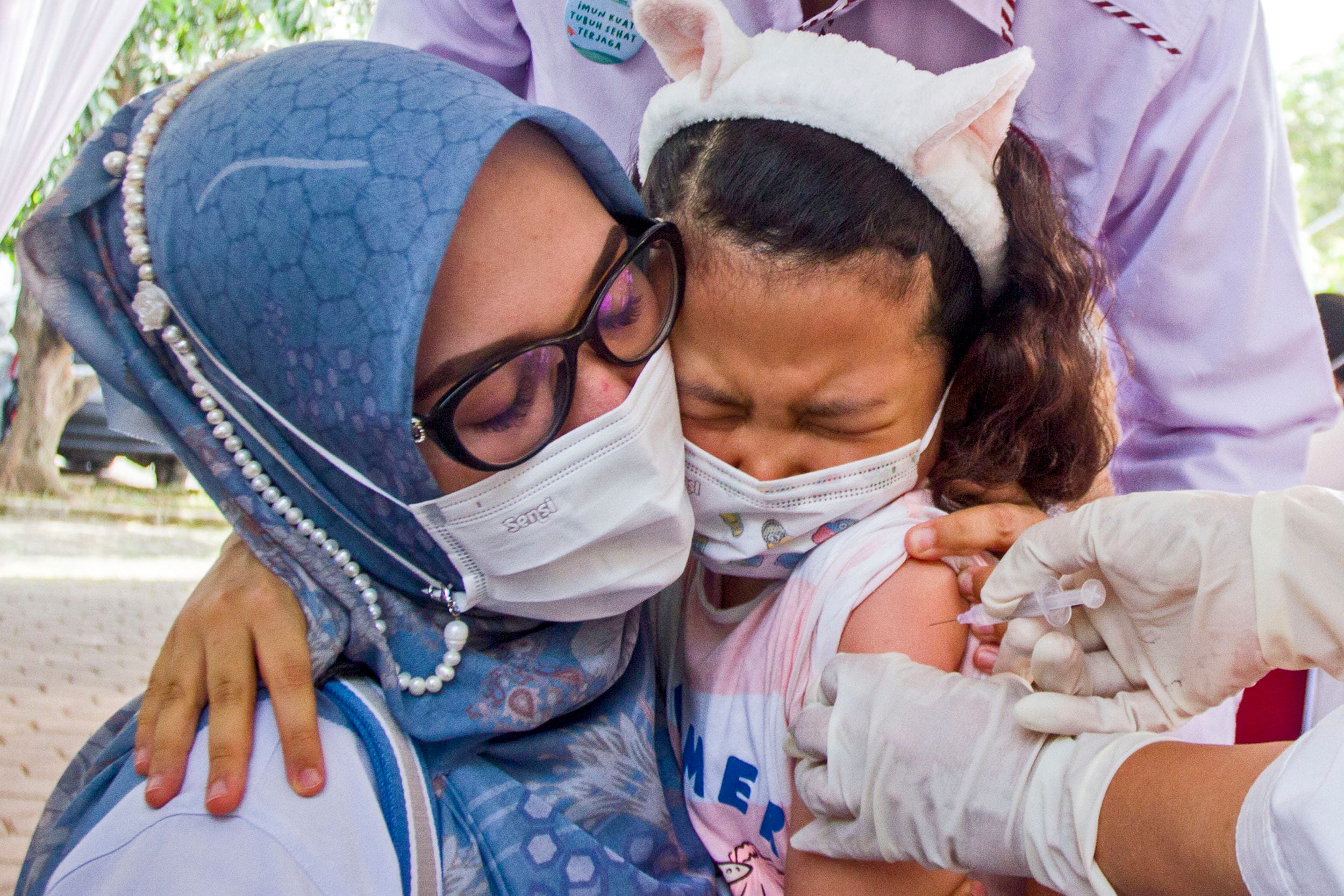 Seorang ibu menemani anaknya saat vaksinasi anak usia 6-11 tahun di Karawang, Jawa Barat, Senin (3/1/2022).ANTARA FOTO/M Ibnu Chazar/aww. VAKSINASI COVID-19 BAGI ANAK DI KARAWANG