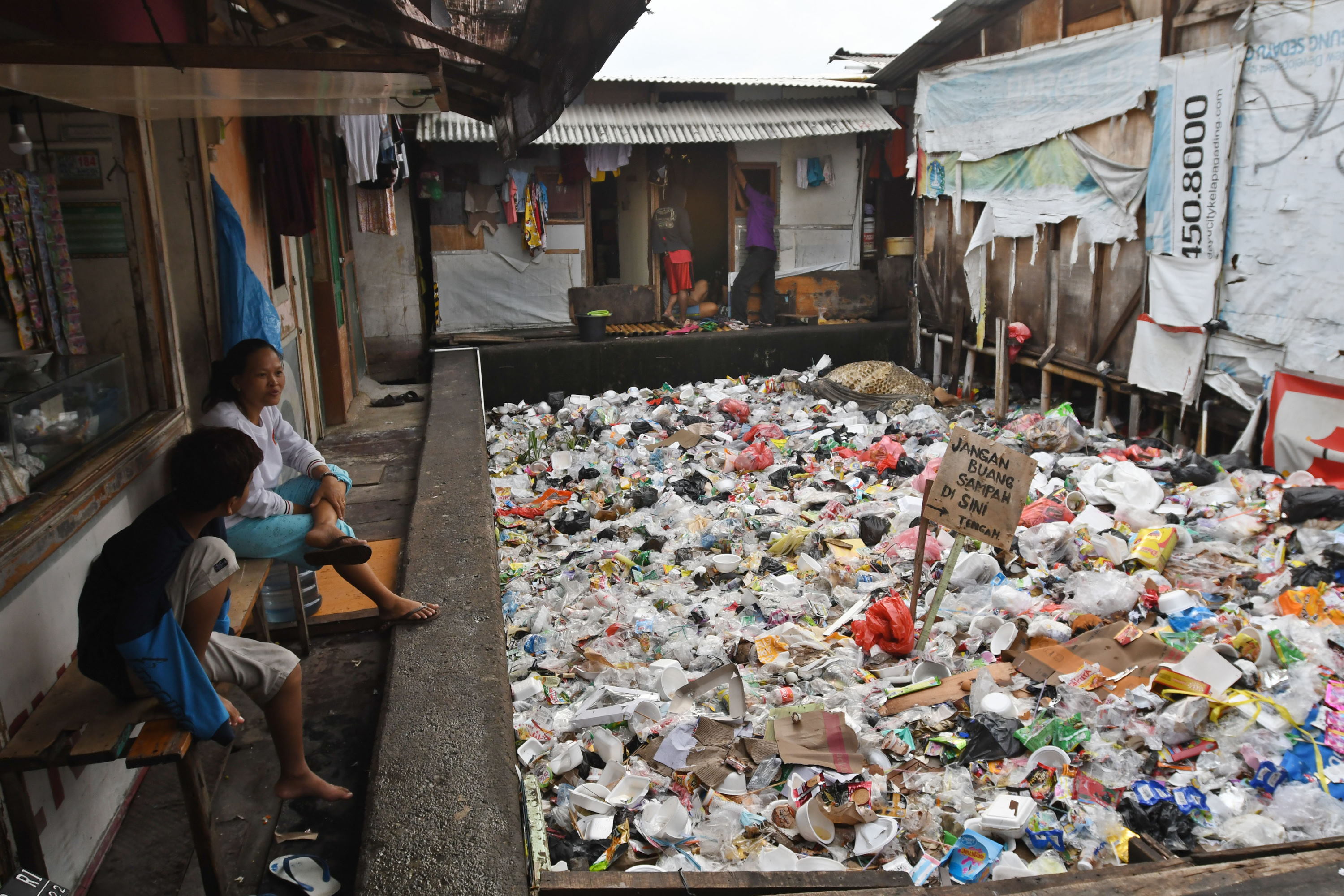 Sejumlah warga mengobrol di perkampungan kumuh tepi rel kereta api di Ancol, Pademangan, Jakarta, Selasa (18/1/2022). ANTARA FOTO/Aditya Pradana Putra/hp. ANGKA KEMISKINAN DI INDONESIA TURUN