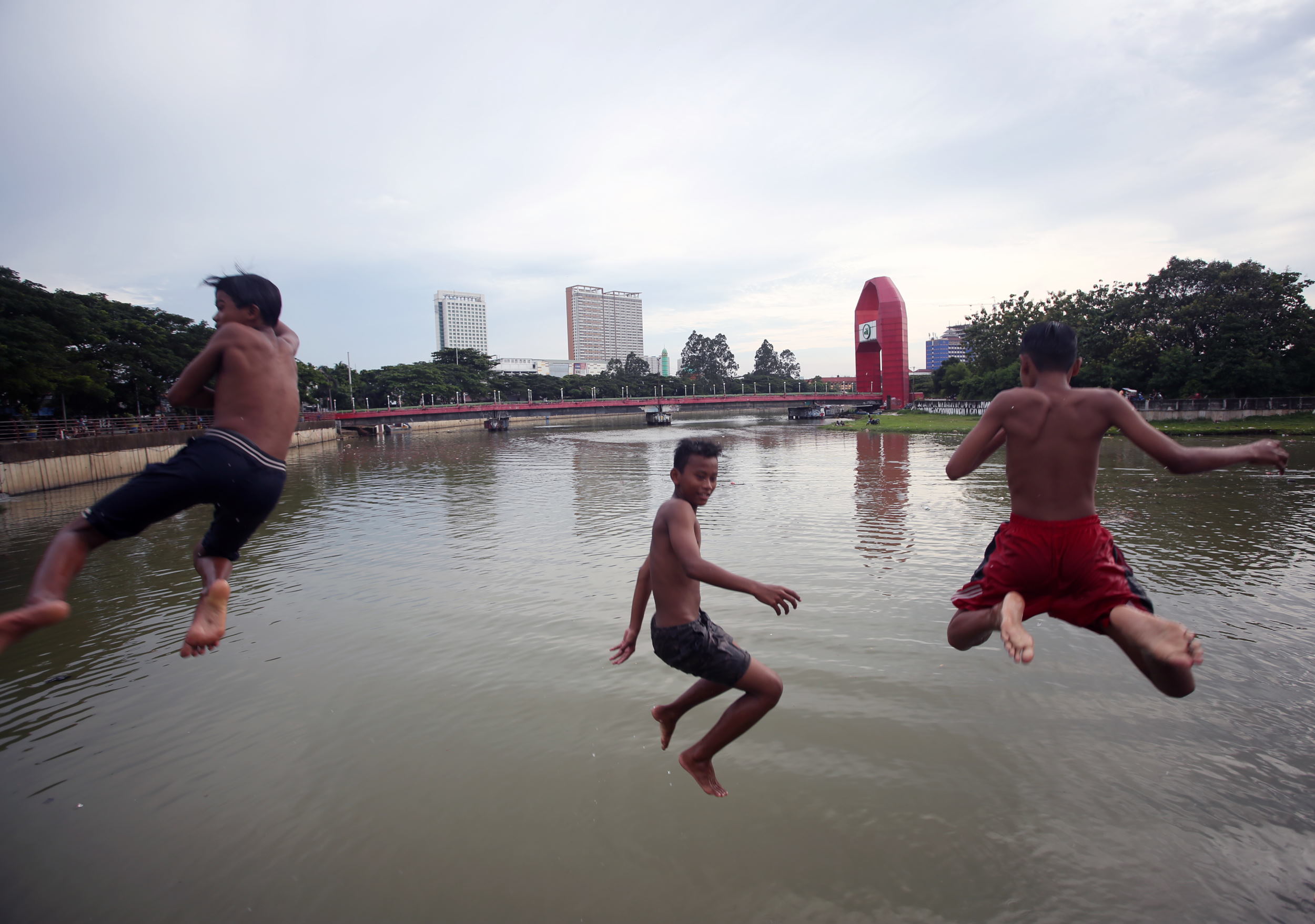 Sejumlah anak melompat untuk berenang di Sungai Cisadane, Tangerang, Banten, Rabu (2/2/2022). . ANTARA FOTO/Muhammad Iqbal/aww. BERENANG DI SUNGAI CISADANE