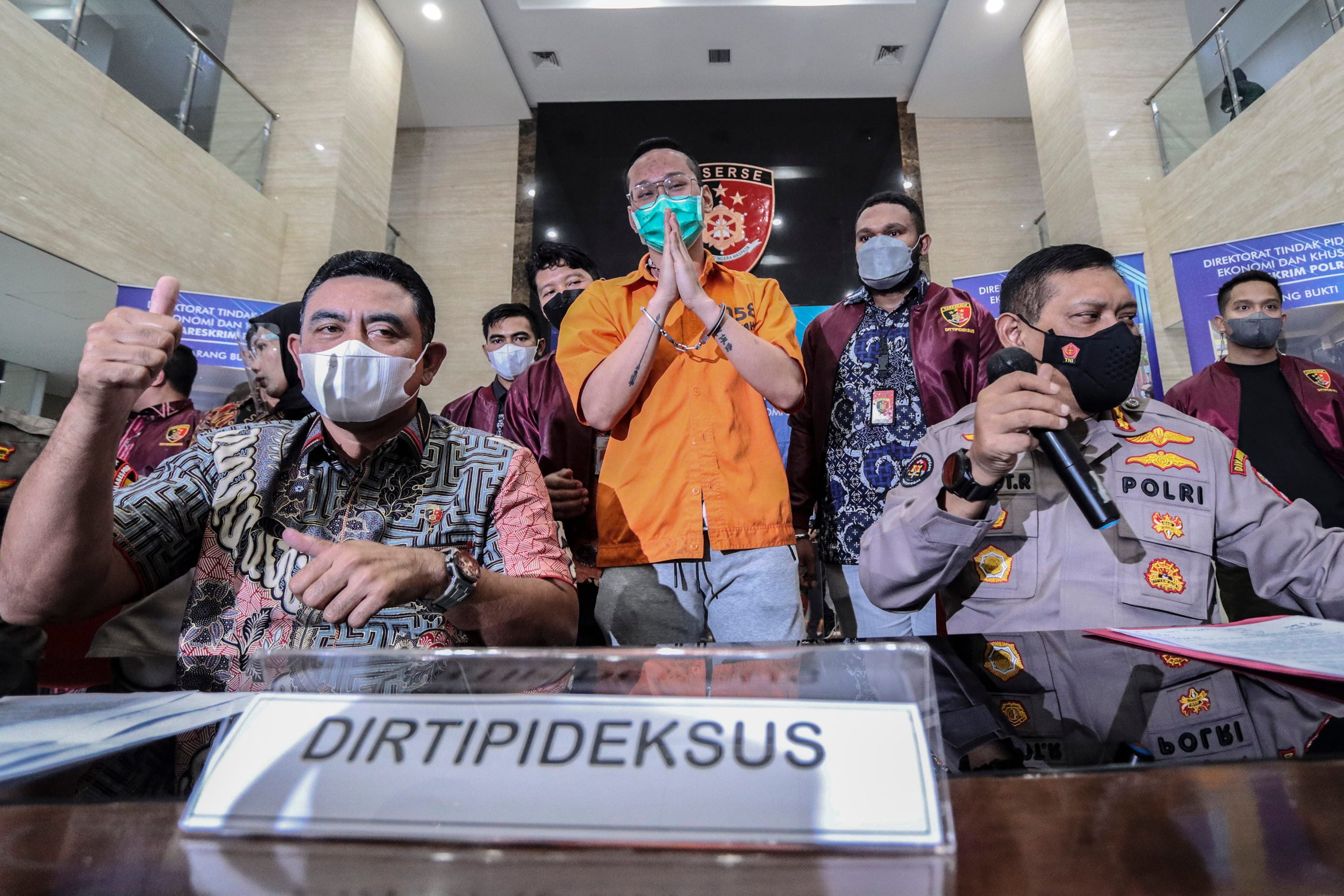 Dirtipideksus Bareskrim Polri Brigjen Whisnu Hermawan (kiri) bersama Kabag Penum Divisi Humas Polri Kombes Pol Gatot Repli Handoko (kanan) memberikan keterangan kepada media saat gelar barang bukti kasus afiliator Binomo dengan Tersangka Indra Kesuma atau Indra Kenz (tengah) di Bareskrim, Mabes Polri, Jumat (25/3/2022). ANTARA FOTO/Adam Barik/Adm/rwa. GELAR BARANG BUKTI INDRA KENZ