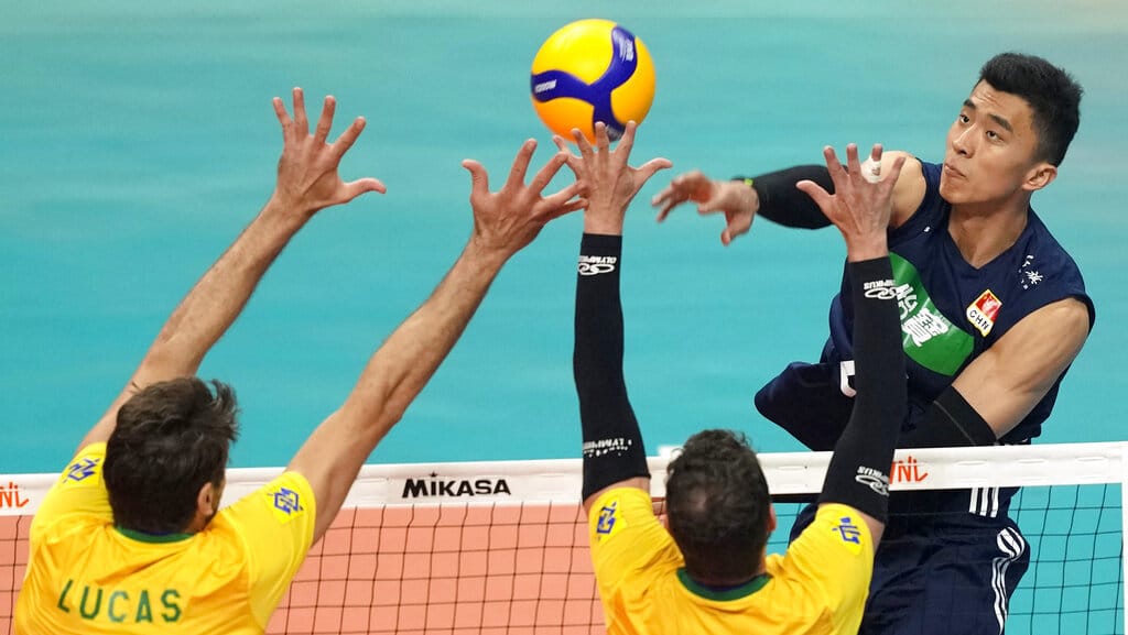 Zhang J.Y melakukan spike ke gawang Lucas dan Bruno dari Brasil dalam pertandingan bola voli Nations League putra di Brasilia, Brasil, Minggu, 12 Juni 2022. (AP Photo/Eraldo Peres) Volleyball Nations League