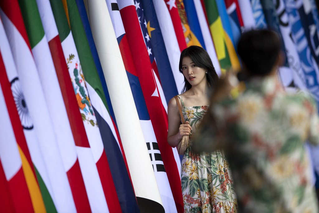 Dua orang wisatawan mancanegara berfoto di depan deretan bendera negara-negara anggota G20 menjelang digelarnya KTT G20 di Nusa Dua, Badung, Bali, Rabu (9/11/2022). Pelaksanaan pertemuan puncak KTT G20 di Bali akan berlangsung pada 15-16 November 2022 mendatang. ANTARA FOTO/M Risyal Hidayat/wsj. MENJELANG KTT G20 DI BALI