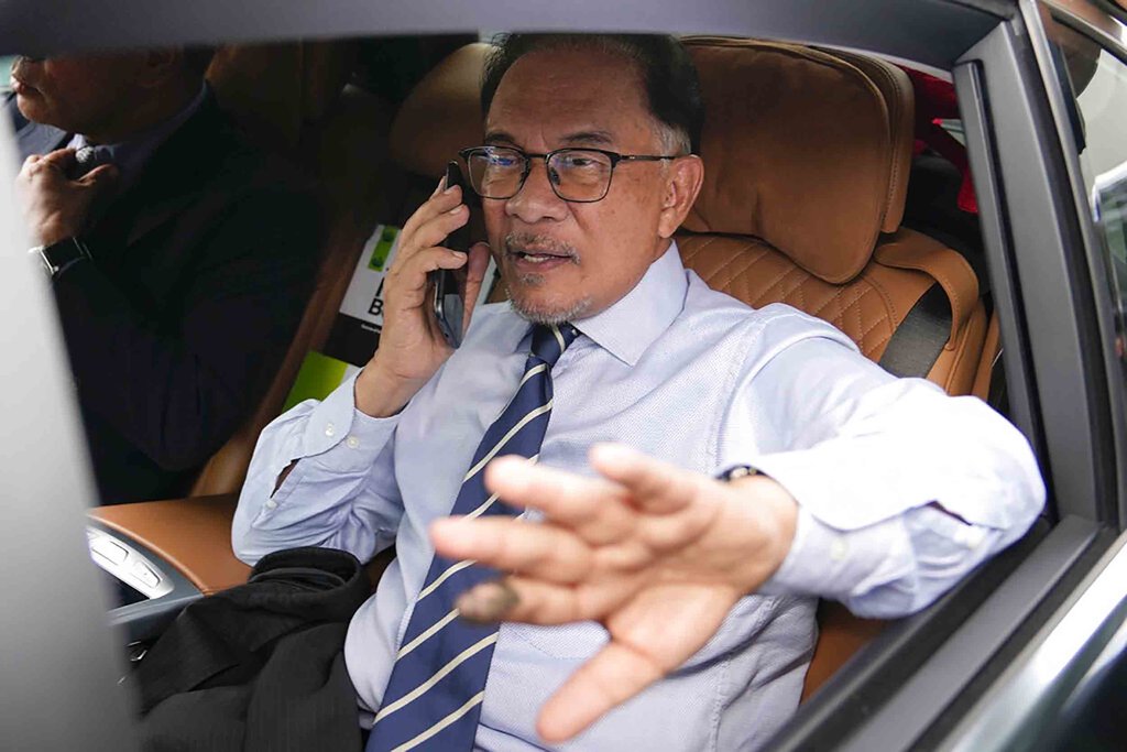 Pemimpin oposisi Anwar Ibrahim, berbicara melalui telepon saat dia meninggalkan kantornya di Kuala Lumpur, Malaysia, Selasa, 22 November 2022. (Foto AP/Vincent Thian) Anwar Ibrahim