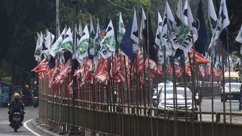 Pengendara melintas di dekat bendera parpol yang terpasang di pembatas jalan kawasan Tebet, Jakarta, Senin (17/7/2023). ANTARA FOTO/Indrianto Eko Suwarso/rwa. Bendera parpol bertebaran
