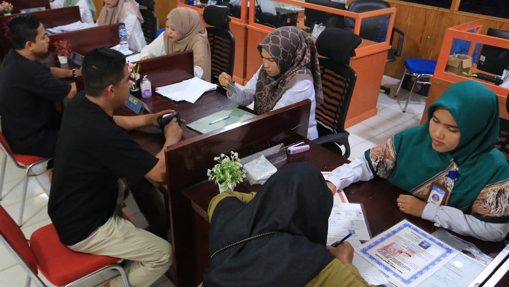Petugas melayani warga saat mengurus Kartu Identitas Anak (KIA) di kantor Dinas Kependudukan dan Catatan Sipil (Disdukcapil) Kabupaten Aceh Barat, Aceh, Rabu (4/10/2023). ANTARA FOTO/Syifa Yulinnas/Spt. Target pembuatan KIA di Aceh Barat