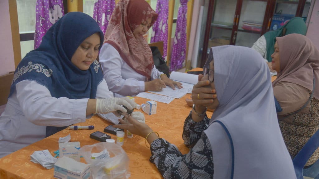 Petugas Puskesmas mengambil sampel darah lansia saat pemeriksaan kesehatan di Pos Pelayanan Terpadu (Posyandu), Kota Banda Aceh, Aceh, Selasa (5/12/2023). ANTARA FOTO/Ampelsa/rwa. Layanan kesehatan lansia