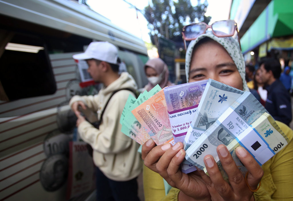 Warga menunjukan uang rupiah baru yang baru saja ditukarkan pada mobil kas keliling Bank Indonesia (BI) di Pasar Palmerah, Jakarta, Senin (18/3/2024). ANTARA FOTO/Muhammad Iqbal Pelayanan penukaran uang di Pasar Palmerah