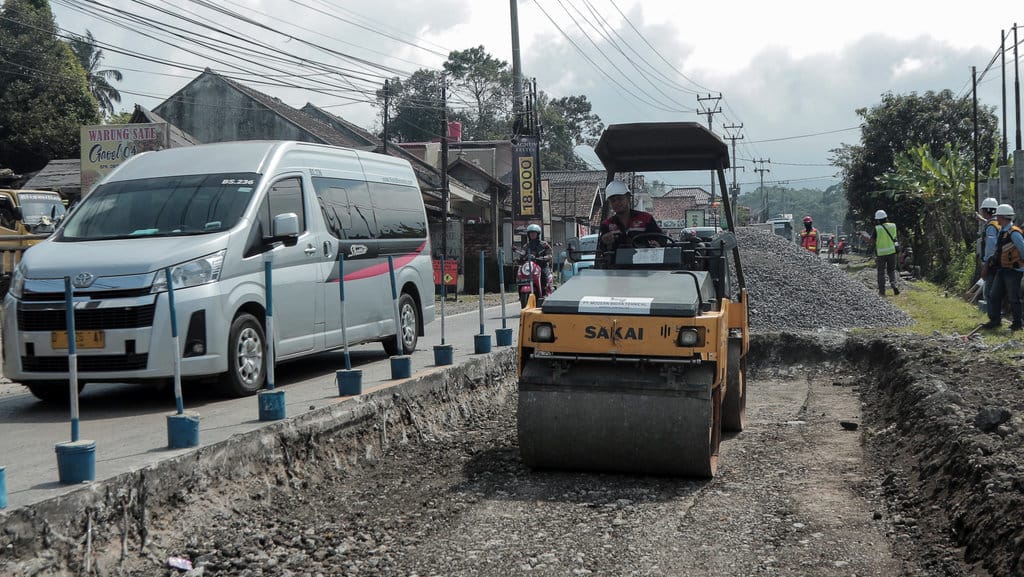 Pekerja mengoperasikan alat berat saat perbaikan jalan di Sukaraja, Kabupaten Sukabumi, Jawa Barat, Kamis (27/6/2024). ANTARA FOTO/Henry Purba/aww. Target rekonstruksi jalan di Jawa Barat